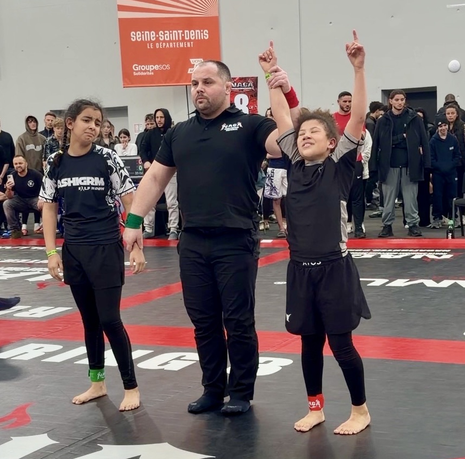 Der Kampfrichter hebt nach einem Sieg an der NAGA Paris ihre Hand, März 2026.